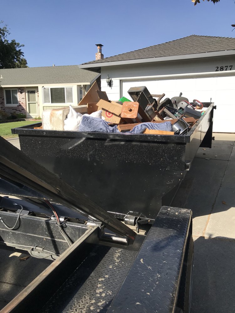 Loaded dumpster on a residential driveway
